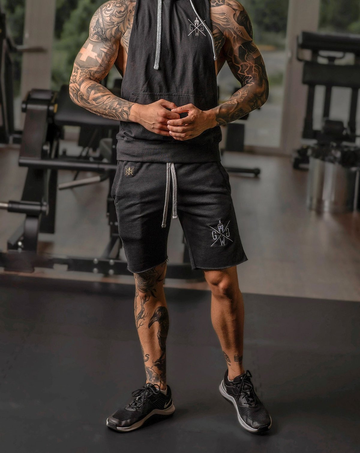 Gym Outfit mit schwarzen Shorts, Tanktop und Sneakern