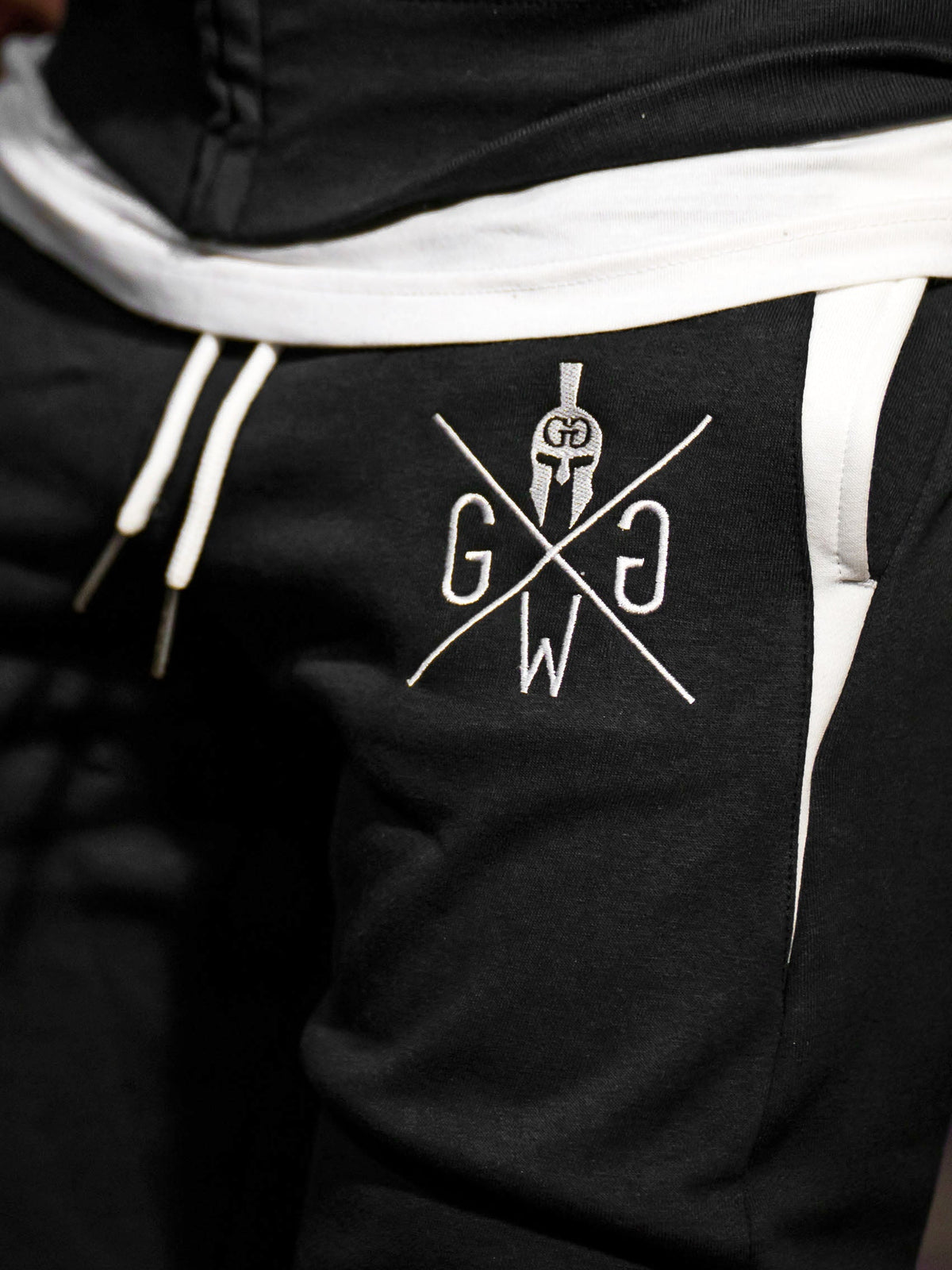 Weiß gesticktes Logo mit Spartanerhelm am Oberschenkel