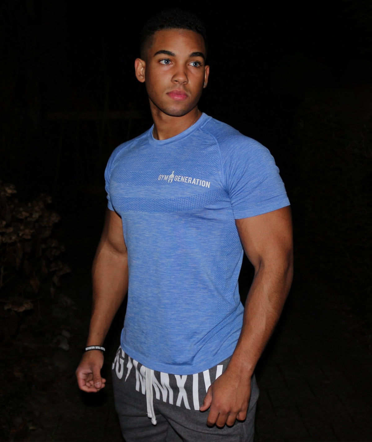 Model trägt das blaue Seamless Fitness Shirt von Gym Generation, eng am Oberkörper mit kurzen Raglanärmeln