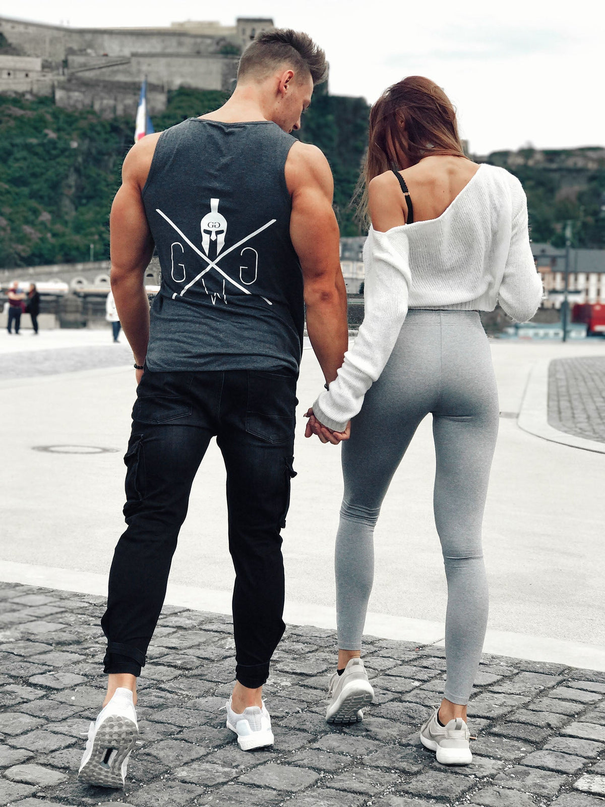 Paar in Trainingskleidung von Gym Generation mit grauem Tank Top und Fitness Leggings