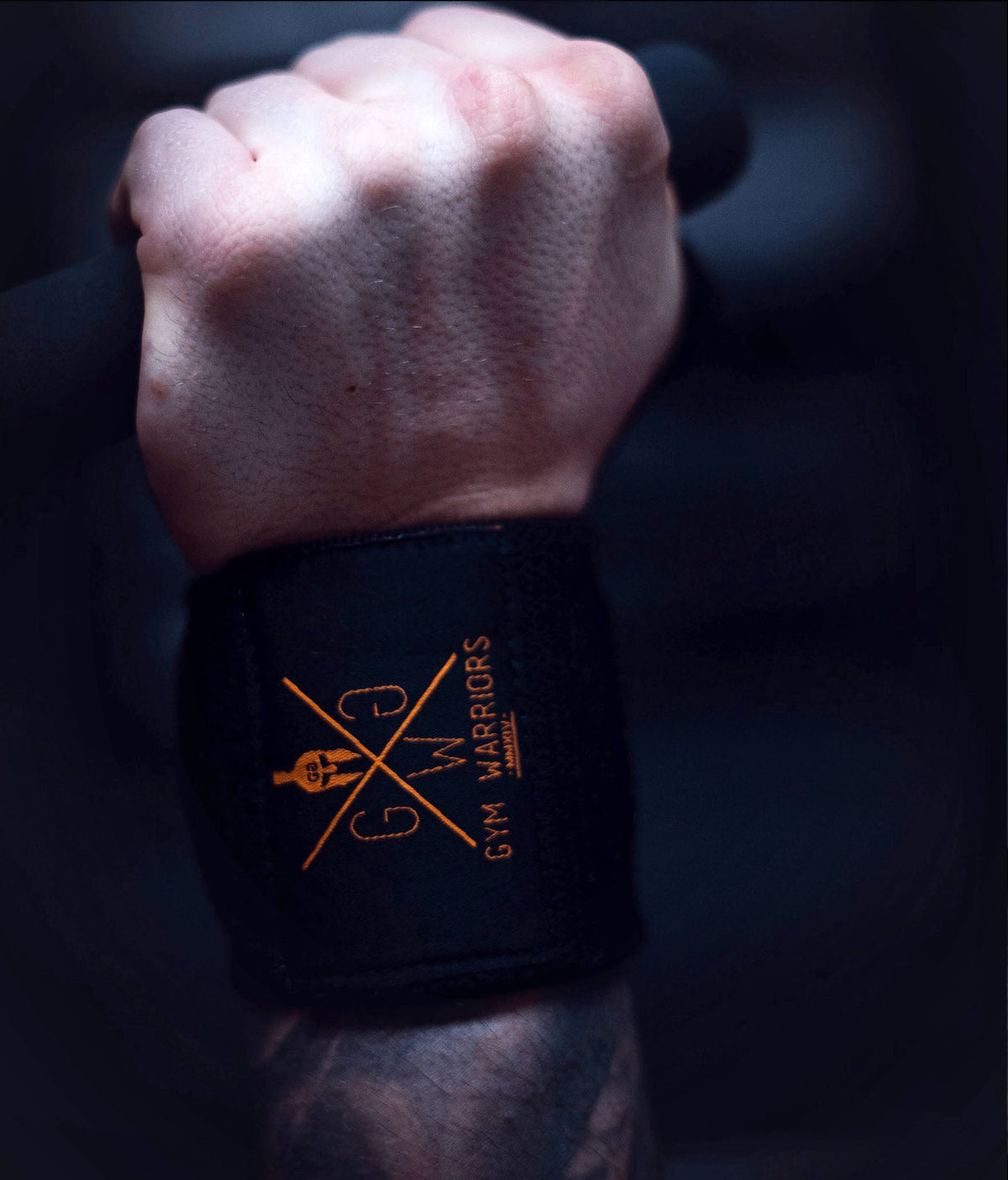 Handgelenkbandage mit gelb-goldenem Logo am Handgelenk