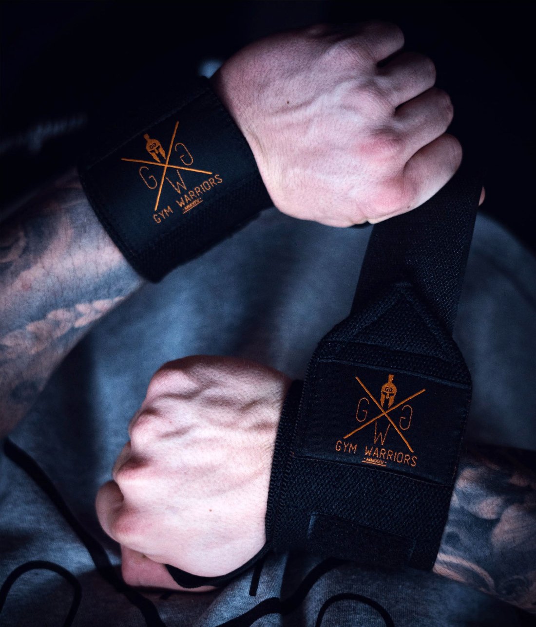 Schwarz-goldene Wrist Wraps an beiden Handgelenken