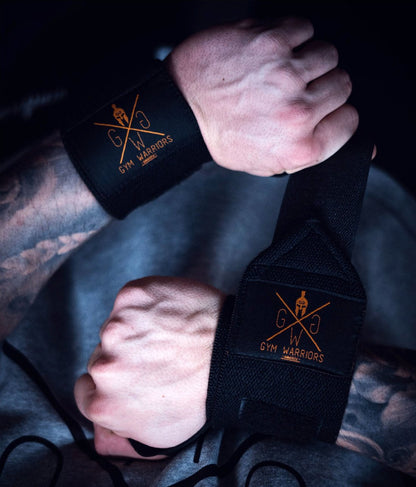 Schwarz-goldene Wrist Wraps an beiden Handgelenken