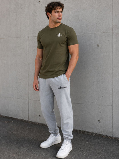 Athlet im oliven Trainingsshirt mit grauer Jogginghose