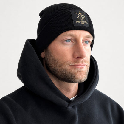 Schwarze Beanie mit goldenem Logo am Model getragen