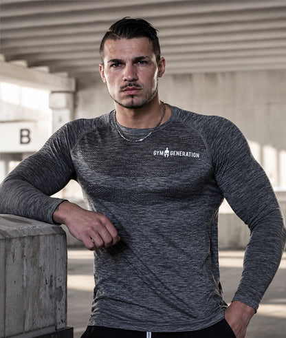 Athlet in grauem Seamless Shirt vor Beton, Schriftzug weiß auf der Brust