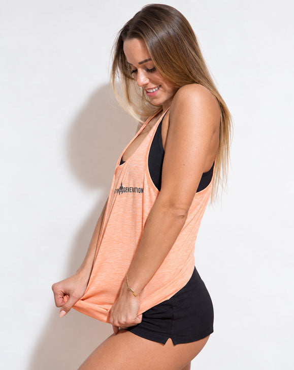 Aprikosenfarbenes Top im Profil mit tiefem Armloch, dazu schwarze Shorts