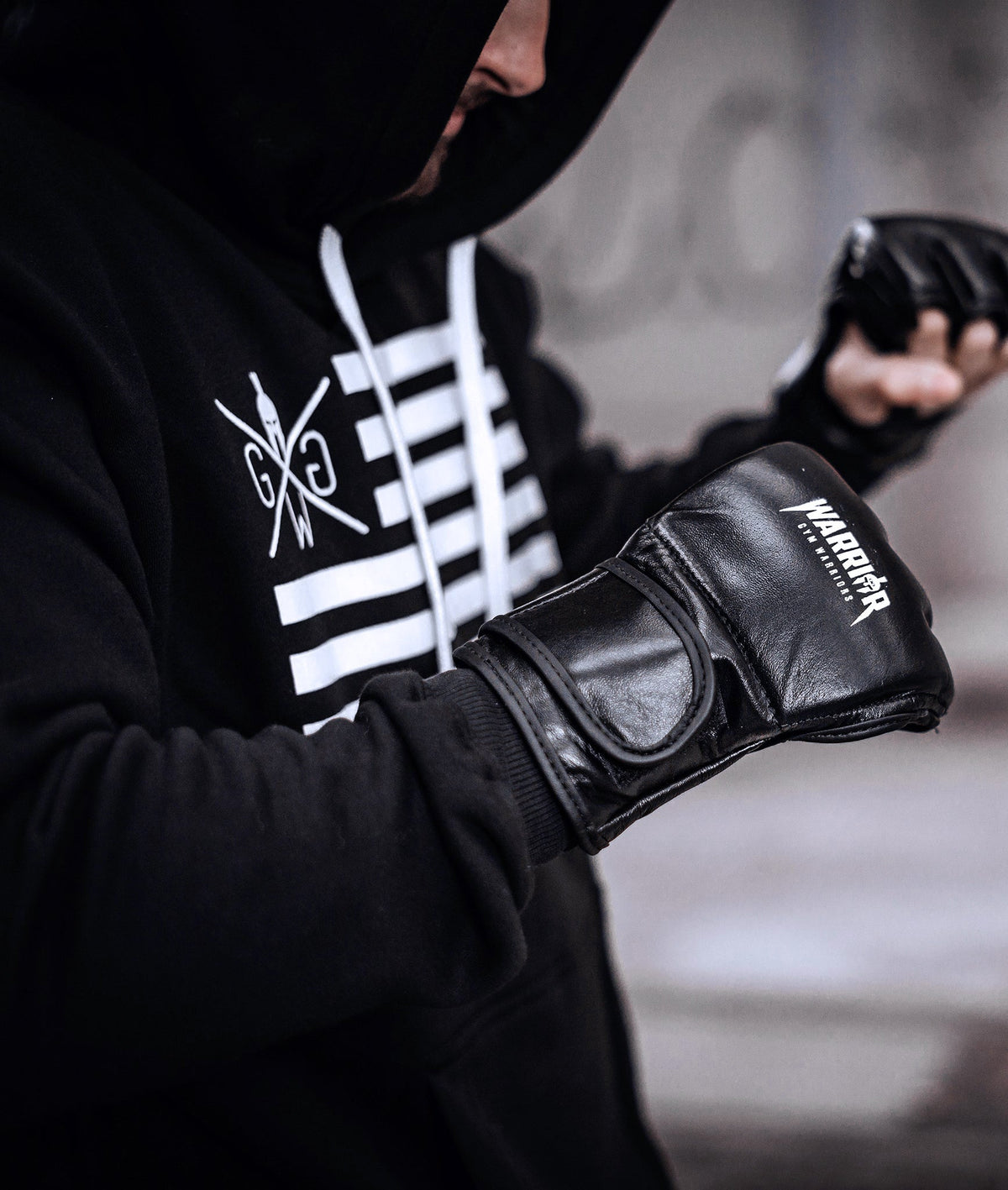 Athlet zieht Trainingshandschuhe an, dazu der schwarze Pullover mit Print