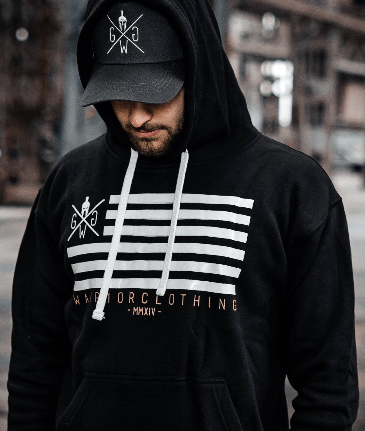 Outfit mit schwarzem Hoodie und Trucker Cap, goldene Schrift unter der Flagge