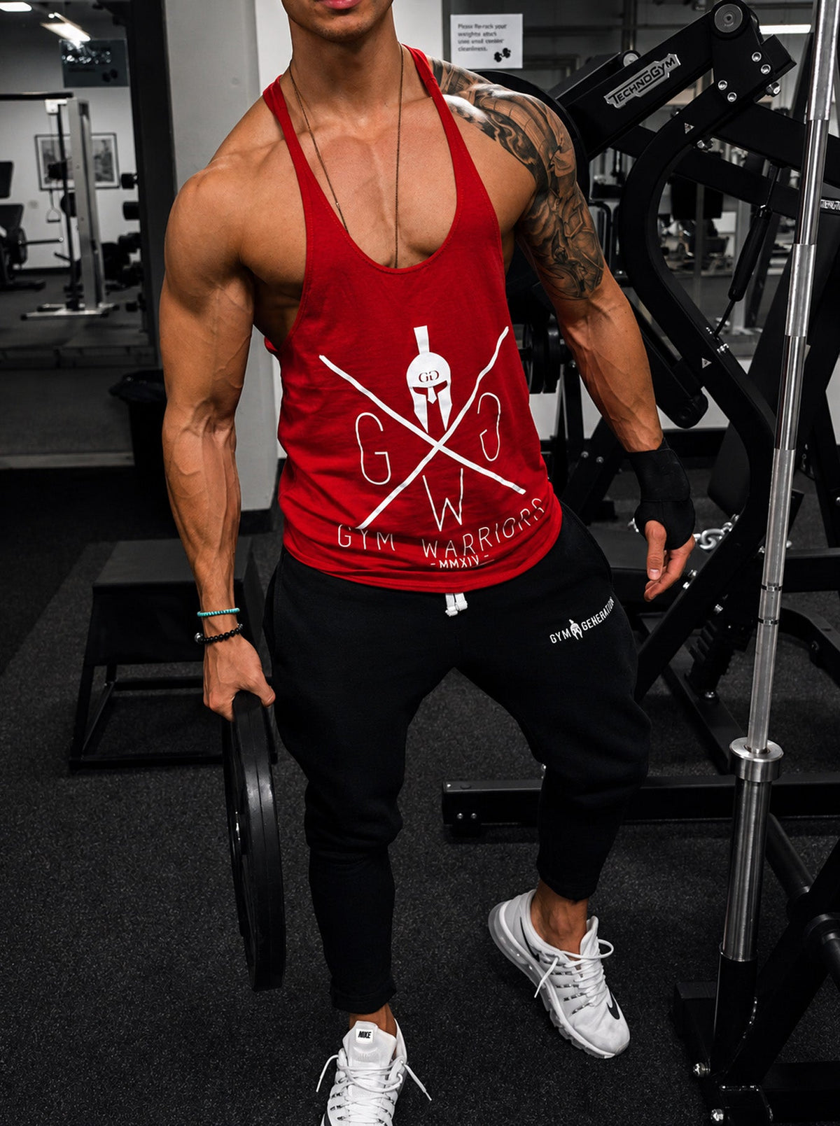 Rotes Tank Top beim Training mit Hantelscheibe
