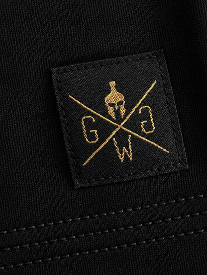 Gesticktes Gym Warriors Label am Saum in Gold auf Schwarz