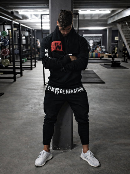 Athlet in schwarzer Jogginghose beim Training im Fitnessstudio