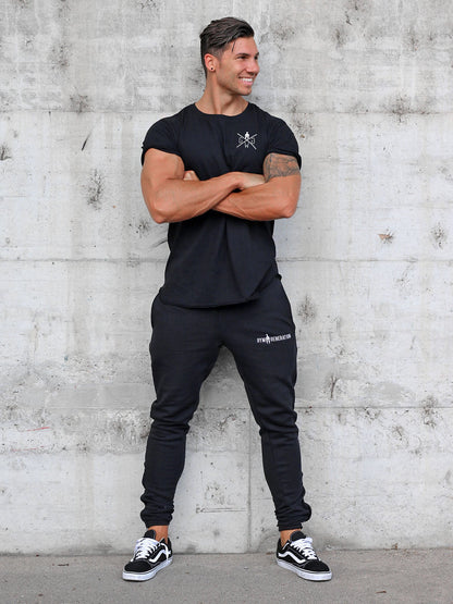 Model trägt die schwarze Fitness-Trainingshose für Herren