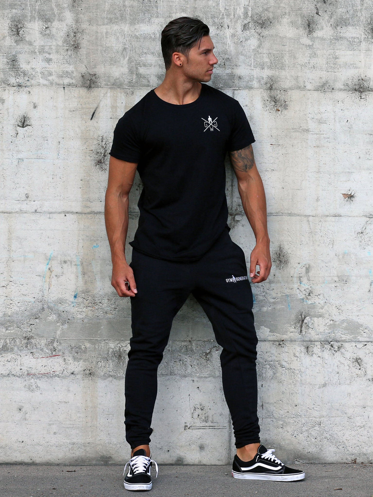 Schwarzes Gym Outfit aus T-Shirt und Trainingshose am Model