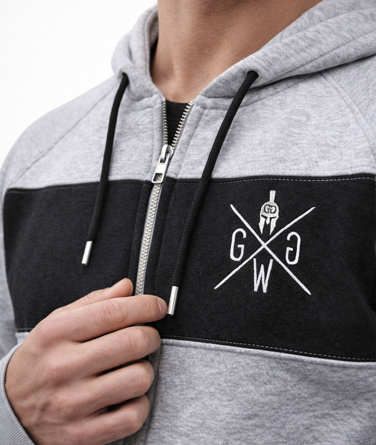 Weiße Logo-Stickerei, Zipper und Kordeln im Detail