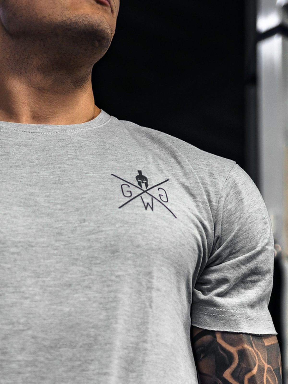 Kleines schwarzes Logo auf der Brust des grauen Shirts