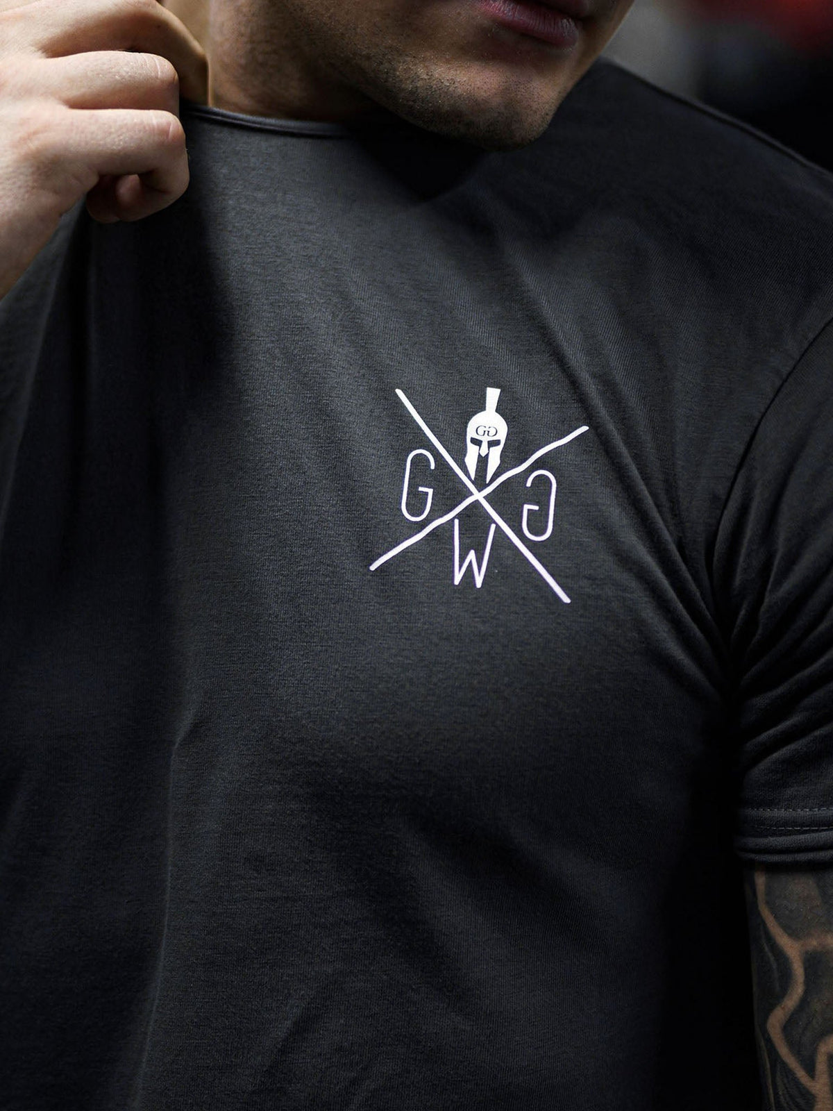 Weißes Logo auf der Brust des dunkelgrauen Shirts im Detail