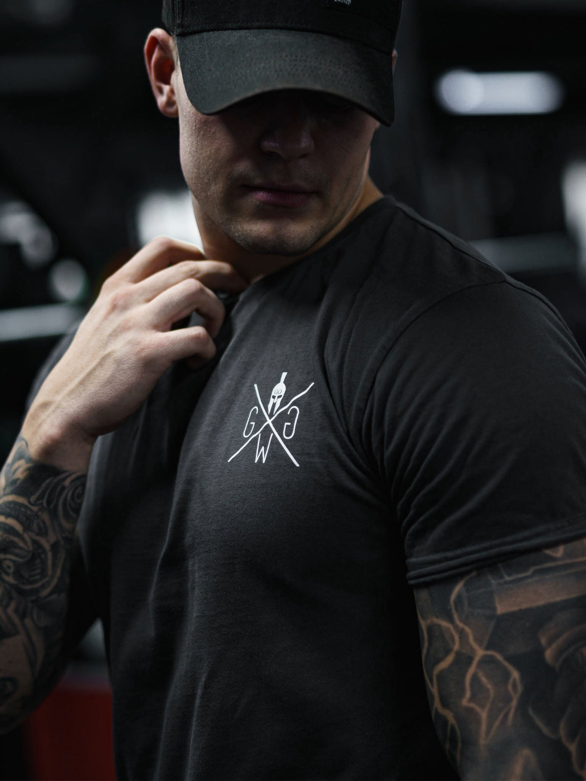 Model im dunkelgrauen Trainingsshirt im Fitnessstudio