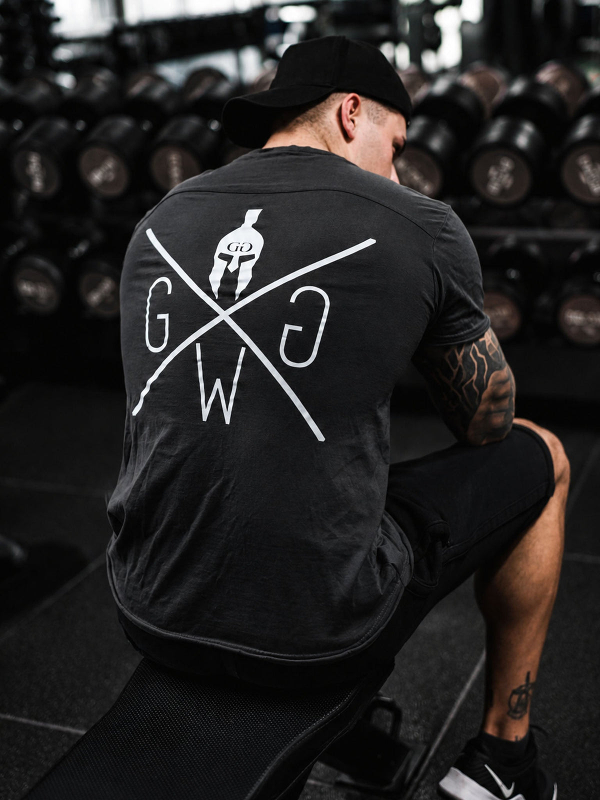 Athlet im dunkelgrauen Warrior Shirt im Gym, Rückenansicht