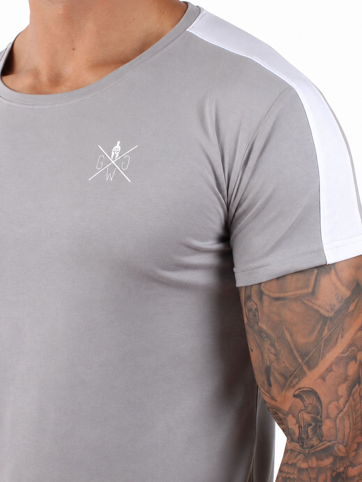 Weißes Logo und Schulterstreifen auf dem grauen Shirt im Detail