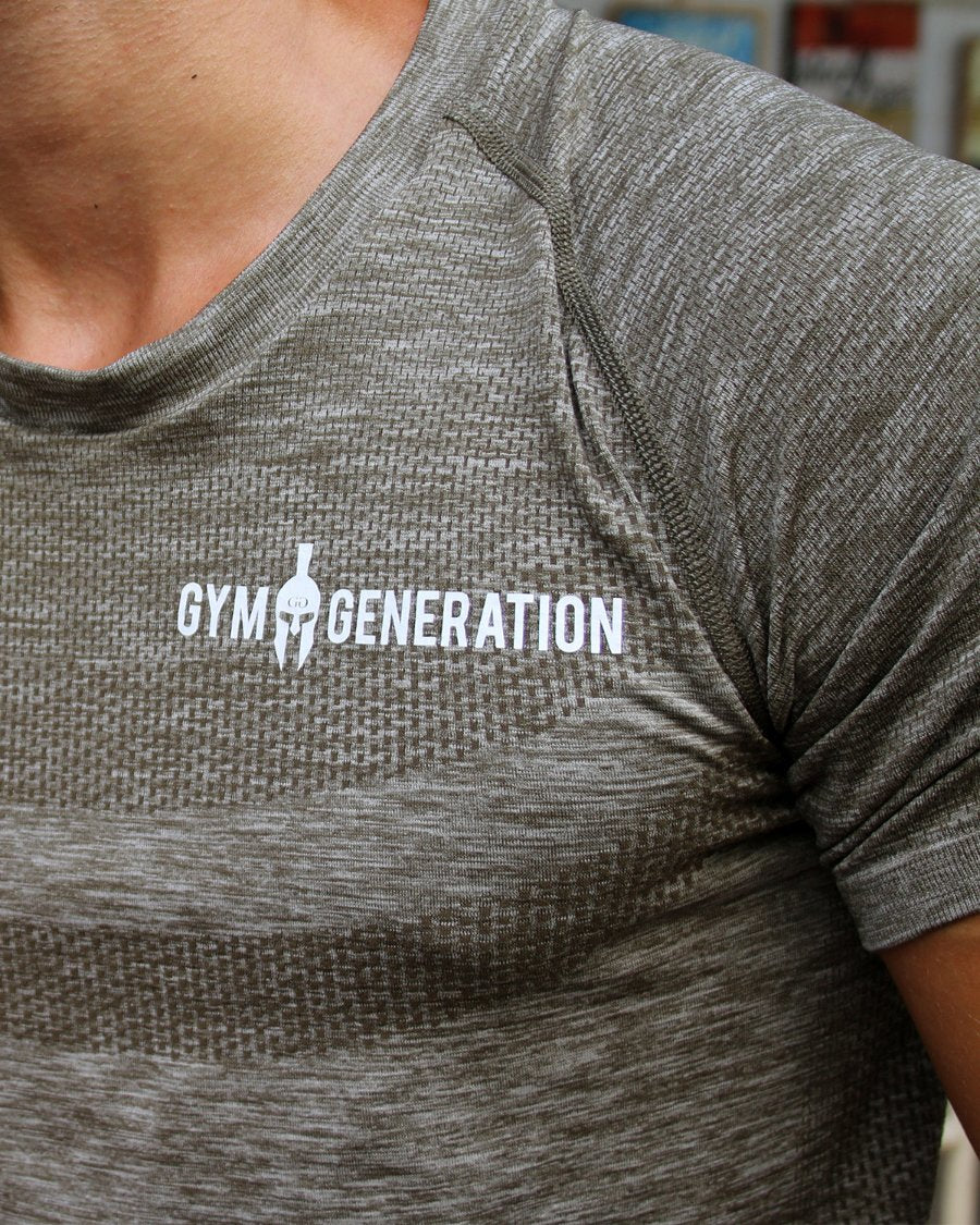 Detailaufnahme vom weißen Gym Generation Schriftzug auf dem Seamless Fitness Shirt in Taupe, mit Wabenstruktur und Raglannaht