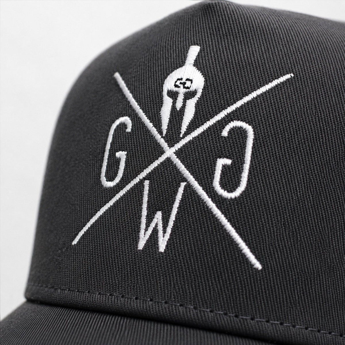Weiß gesticktes Gym Generation Logo auf dunkelgrauem Stoff